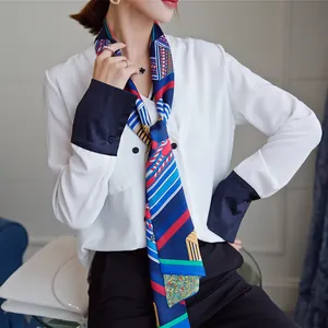 Detailed styling of geometric striped twilly scarf tied on a white shirt collar