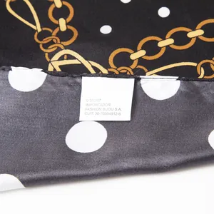 Detail of silk scarf with polka dots, gold chains, and neat edge stitching finish