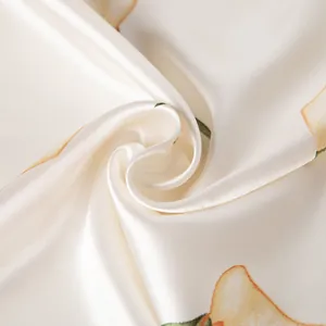 Macro detail of glossy pear print silk scarf showing smooth satin texture and soft drape