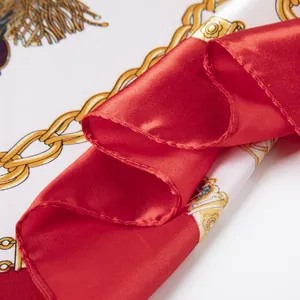 Détail d'un foulard en soie avec motifs de chaînes royales et tissu rouge satiné