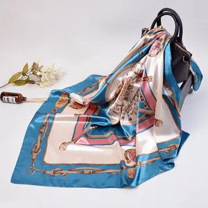 Foulard en soie 90x90cm aux motifs équestres classiques drapé sur un sac à main chic