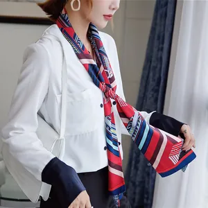 Elegant long silk scarf with geometric red and blue stripes styled on a white shirt