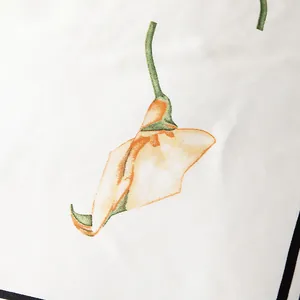 Close-up of elegant white silk scarf featuring vibrant orange calla lily floral patterns