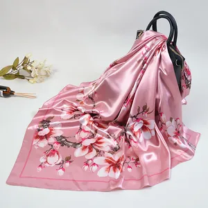 Carré en satin rose avec imprimé floral de fleurs de cerisier drapé sur un sac