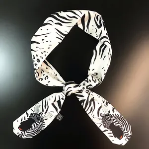 Detail of zebra and leopard print satin scarf tied in a bow with realistic zebra motif