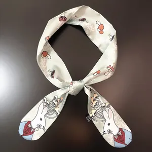 Detail of mint green silk twilly featuring cartoon rabbits and mushroom illustrations