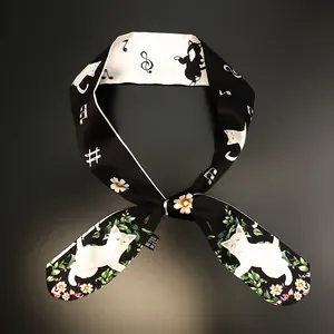 Detail of silk twilly scarf with cute cartoon cats, floral patterns and musical notes