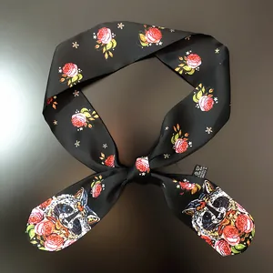 Detail of a black polyester scarf showing raccoon print, floral pattern, and the care label