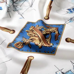 Detail shot of white silk scarf with blue nautical shield and gold heraldic patterns