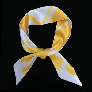 Détail du foulard twilly en soie jaune et blanc avec motif géométrique et fini brillant