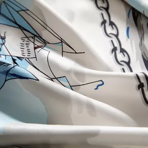 Detail of nautical sailing silk scarf showing glossy twill texture and blue anchor print