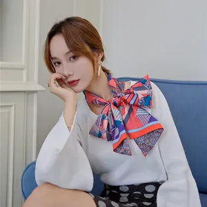 Detail of silk scarf tied as elegant bow with orange and blue geometric pattern