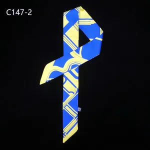 Détail d'un foulard twilly à rayures géométriques bleu roi et jaune vif avec texture soie