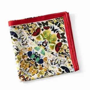 Detail eines Seidenschals mit buntem Schmetterlingsdruck und breitem rotem Rand