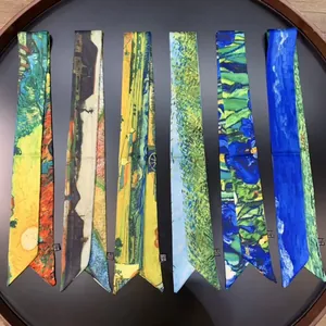 Macro shot of assorted silk twilly scarves with Van Gogh art prints in a wooden tray