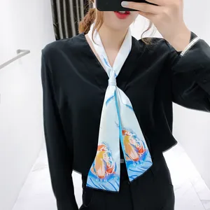 Dettaglio di un foulard in seta sottile con piume azzurre e stampa dei Pesci