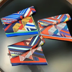 Close-up of assorted geometric striped satin silk scarves with vibrant color blocks