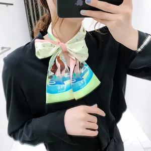 Dettaglio di un foulard in seta con motivi zodiacali annodato a fiocco elegante