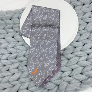 Macro shot of 100% silk tie featuring gray bird patterns and purple geometric inner lining