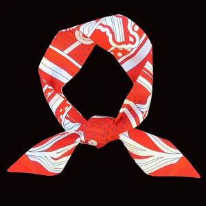 Dettaglio di un foulard in seta con motivi geometrici vivaci annodato con cura