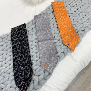 Detailed view of three satin ties with white bird patterns on a textured grey blanket