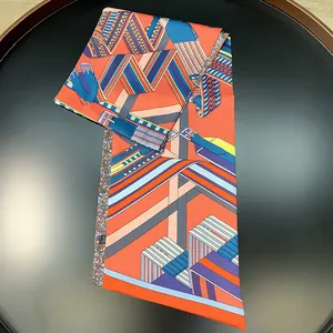 Detailed close-up of geometric belt print on a luxury silk twilly scarf in orange and blue