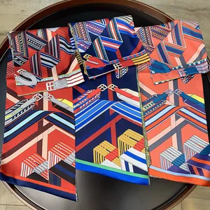 Three colorful geometric stripe silk scarves with belt patterns on a wooden tray