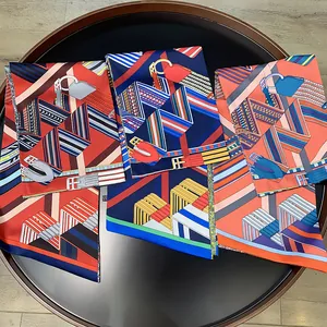 Detailed view of striped geometric patterns and leather belt motif on luxury silk scarves