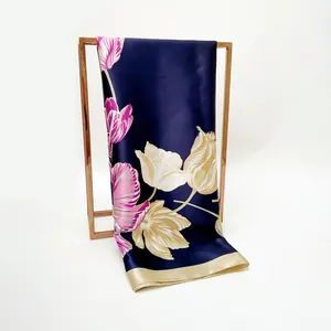 Navy blue faux silk scarf with tulip floral print and golden borders on a metal stand