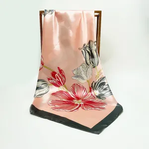 Pink satin square scarf with tulip floral print and black border on a metal stand