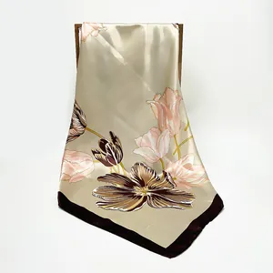 Champagne gold satin scarf with tulip floral print hanging on a dark wooden rack