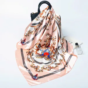 Baroque royal pattern silk square scarf in pink and white draped on a black handbag