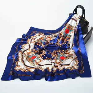 Royal baroque silk square scarf with gold jewel print draped over a black leather handbag