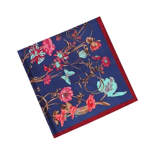 Detail of floral and butterfly print on navy silk square scarf with red hemmed edges
