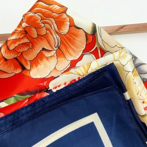 Detailed macro view of silk satin scarf featuring realistic floral patterns and rolled edges