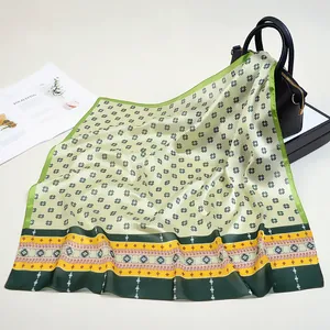 Dettaglio di un foulard in seta con motivi a trifoglio su una borsa di pelle elegante
