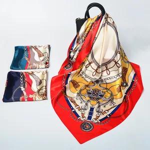 Detail of baroque silk scarves with gold chain patterns draped on a handbag