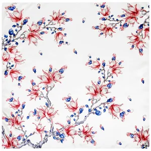 Vista piatta di un foulard in seta con stampa di magnolia, petali cremisi e rami blu