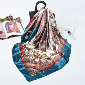 Elegant peacock blue square silk scarf with vintage belt and chain patterns on a handbag