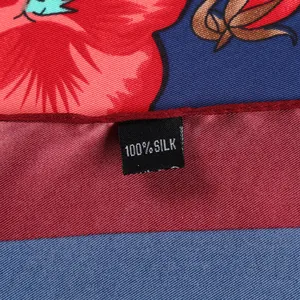 Detailed close-up of 100% silk floral scarf showing fabric texture and premium tag