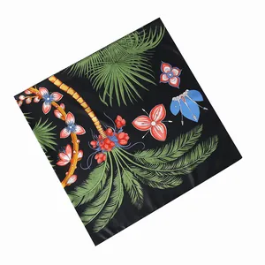 Dettaglio di foglie di palma tropicale e fiori rossi su sciarpa di seta nera