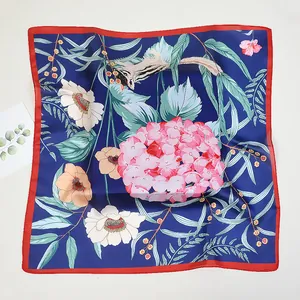 Detail of silk scarf featuring squirrel and sunflower patterns on navy blue background