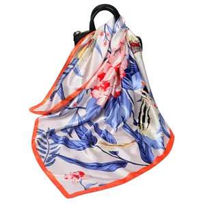 90cm satin square scarf with floral pattern and orange border on black leather handbag