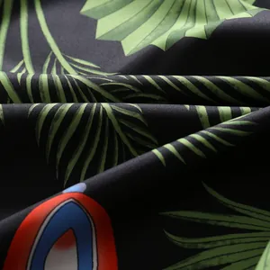 Dettaglio del tessuto effetto seta con stampe di palme tropicali e texture lucida