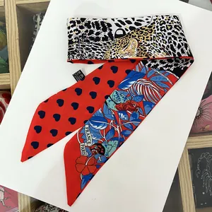 Détail d'un foulard en soie avec imprimé léopard, cœurs et étiquette France Paris chic