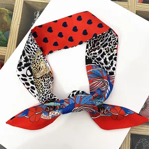 Gros plan d'un foulard en soie avec imprimé léopard et cœurs rouges sur fond blanc