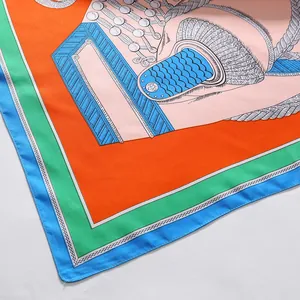 Macro detail of silk-like scarf with vibrant rope jewelry prints and neat hemmed edges