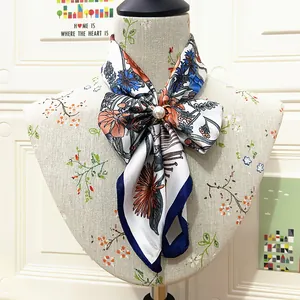 Floral print 60cm silk scarf with pearl buckle accessory on a mannequin display