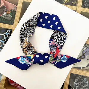 Détail d'un foulard en soie avec imprimé léopard, cœurs bleus et motifs floraux