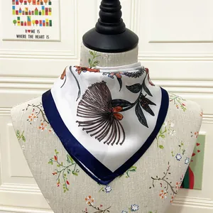 Detail of a 60cm silk square scarf with navy borders and botanical flower prints